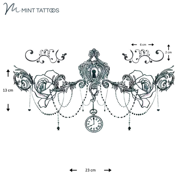 13 x 23 cm sheet contains 3 different tattoos. Main is a scroll centerpiece with a keyhole and vine like extensions with a rose on each side, with draping beads.  Other 2 are small scroll designs