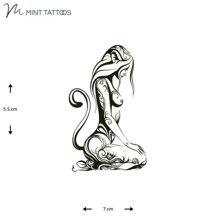 Temporary tattoo from Mint Tattoos long haired woman kneeling with hands on lap. Side profile silhouette with scroll design and a cat like tail